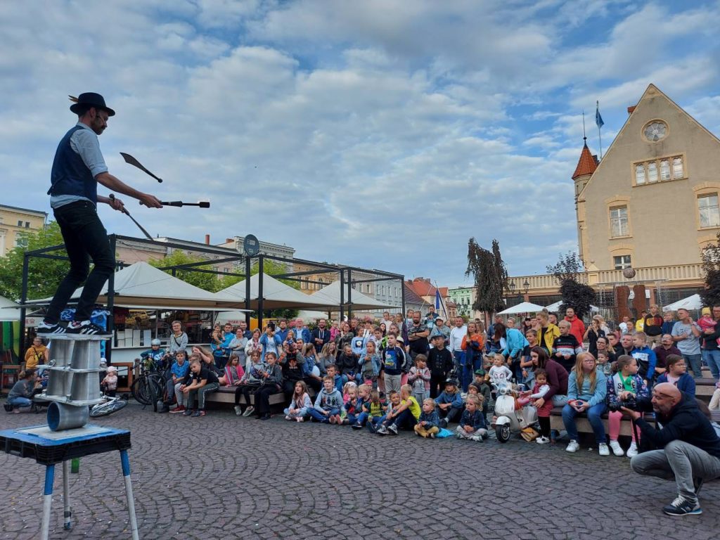 Richard Filby juggling knives while standing on rola bola  