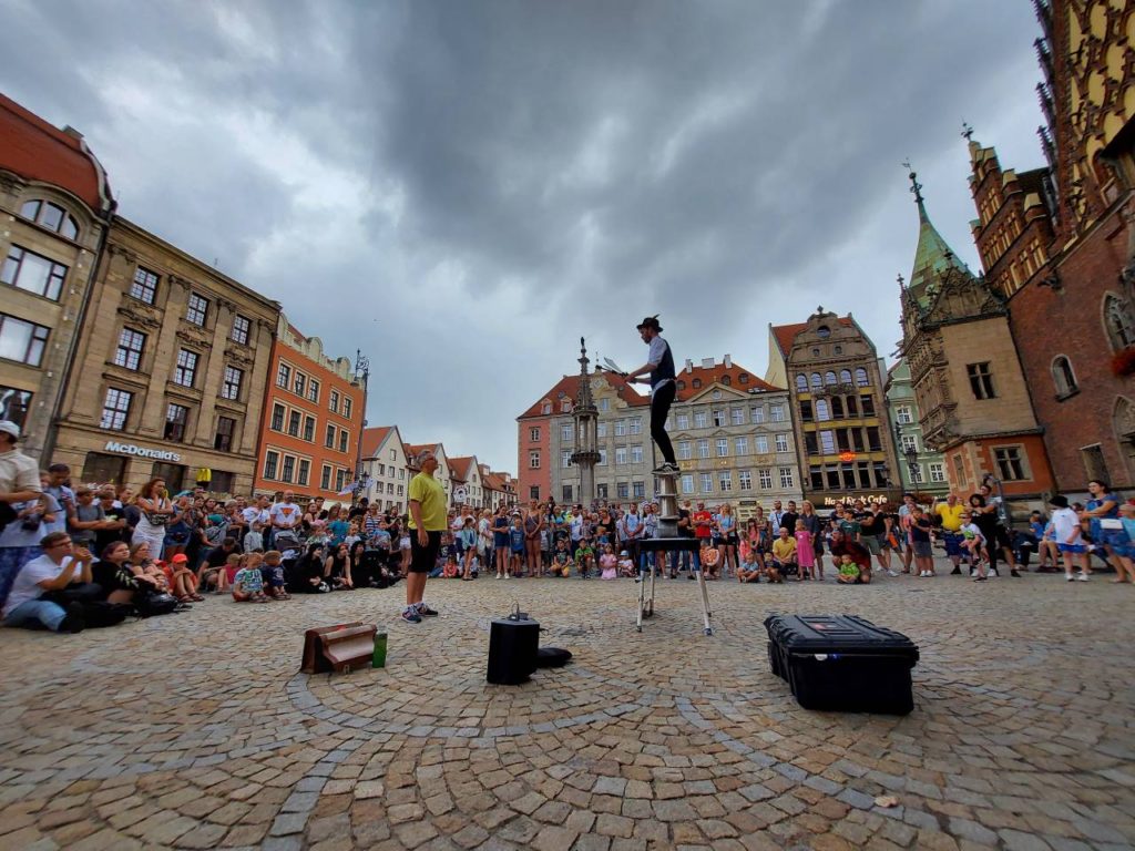 Busker Richard Filby balansuje na rola boli na Rynku we Wrocławiu