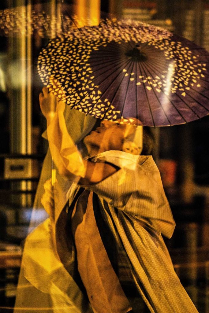 Artysta uliczny tańczy z parasolką