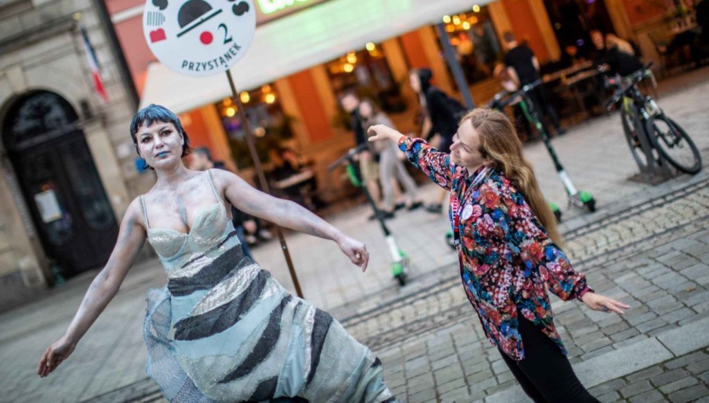 Małgorzata Węglarz stands next to living statue dressed as mermaid