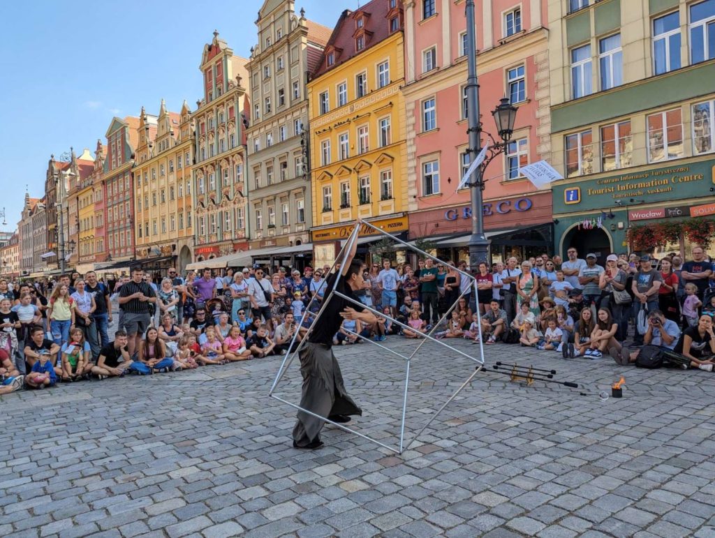 Tłum ogląda pokaz artysty ulicznego z pokazem cyrkowym