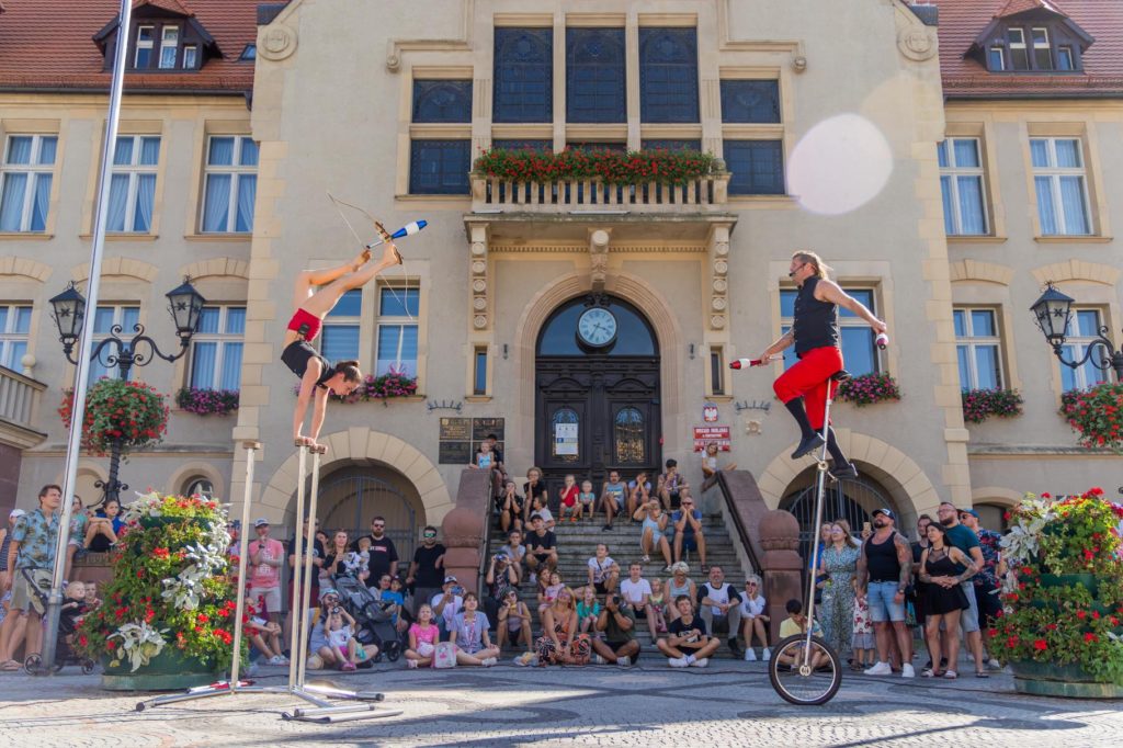 Foot archery, acrobatics and unicycle circus act by MulletMan and Mim during street show at Busker Tour