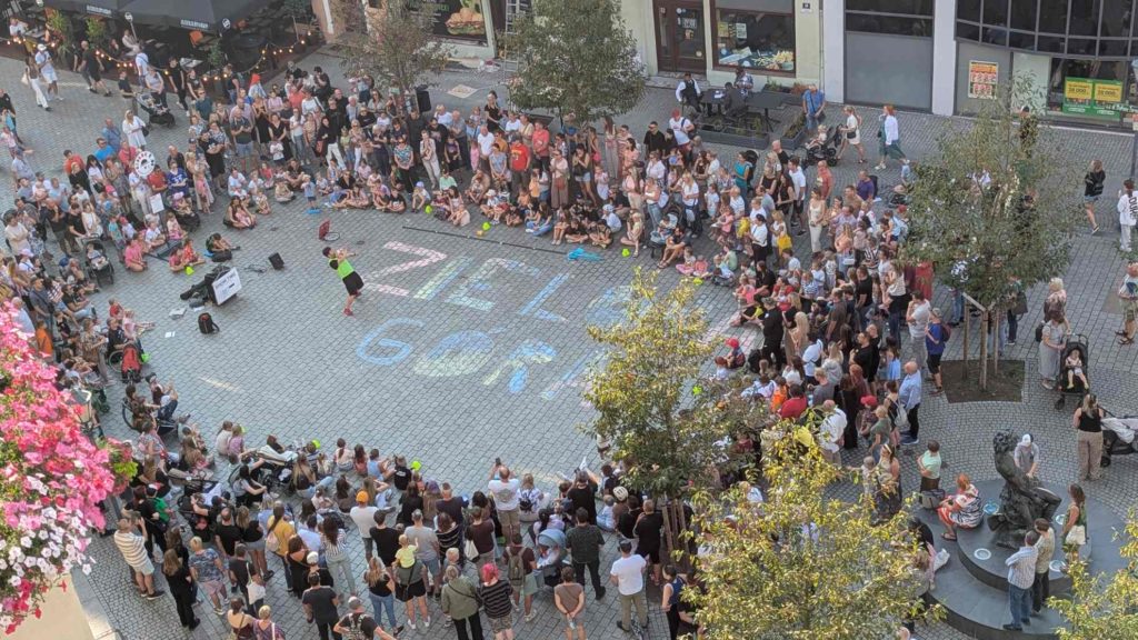 Tłum oglądający pokaz uliczny buskera Stefana Florescu na deptaku w Zielonej Górze podczas festiwalu Busker Tour.
